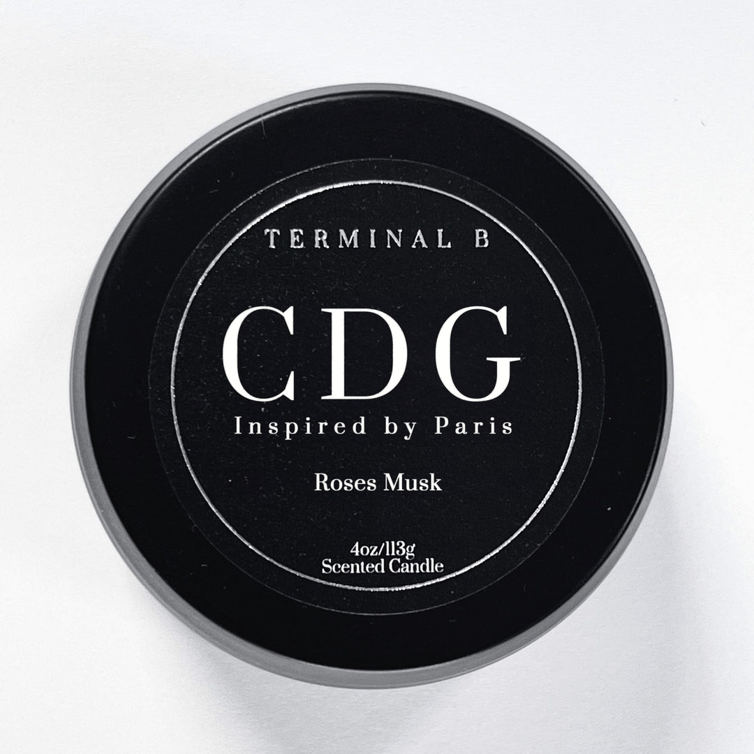 CDG 4oz Travel Tin candle by Terminal B. Roses Musk fragranced and displayed against a white background. Inspired by Paris, carefully designed for an elegant, long-lasting scent.