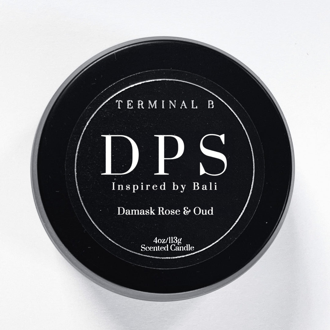 DPS 4oz Travel Tin candle by Terminal B. Damask Rose & Oud fragranced and displayed against a white background. Inspired by Bali, carefully designed for an elegant, long-lasting scent.