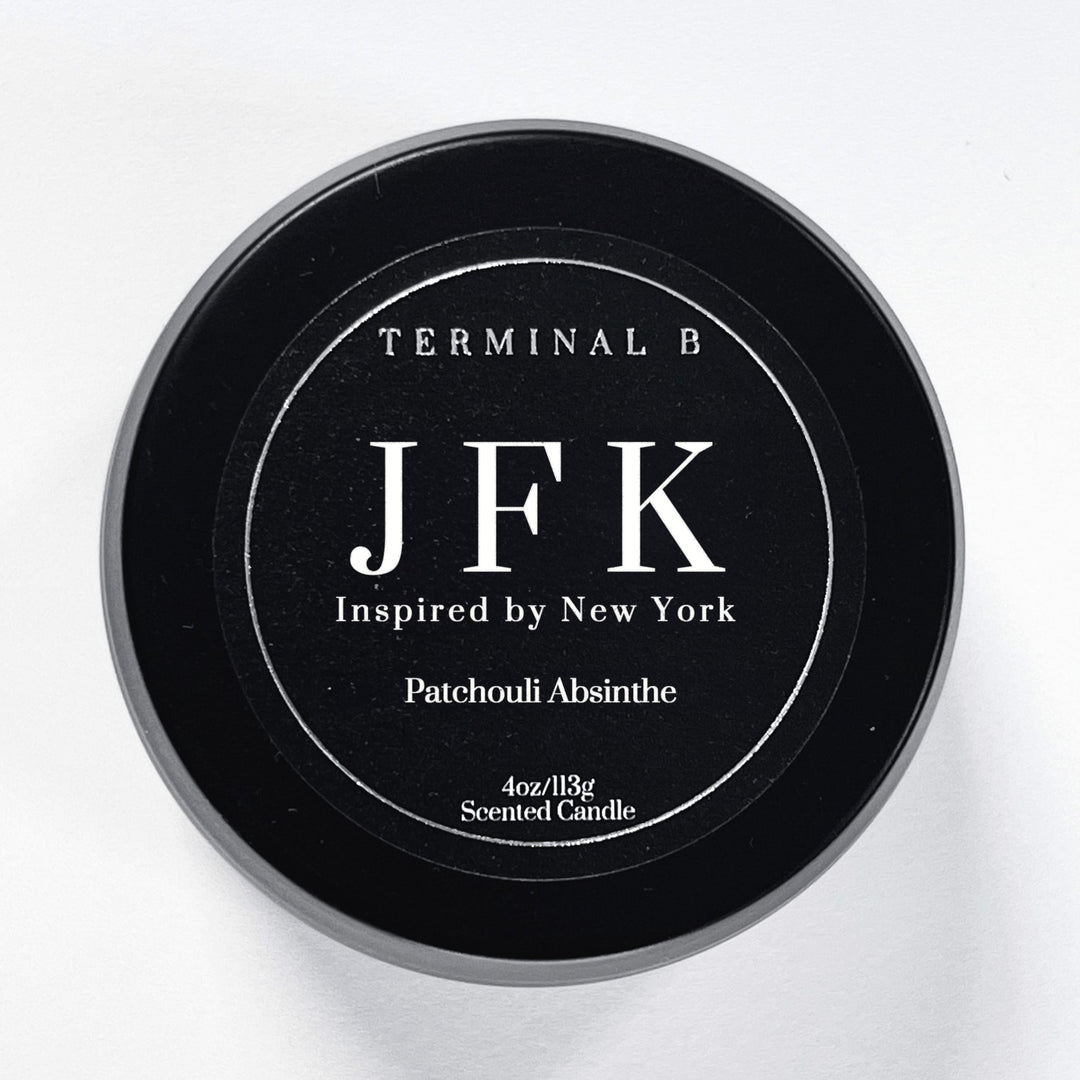 JFK 4oz Travel Tin candle by Terminal B. Scented in Patchouli Absinthe fragrance, displayed against a white background. Inspired by New York, carefully designed for an elegant, long-lasting scent.