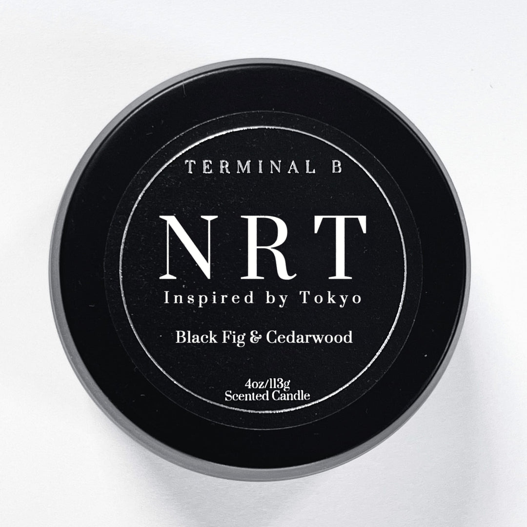 NRT 4oz Travel Tin candle by Terminal B. Black Fig & Cedarwood fragranced and displayed against a white background. Inspired by Tokyo, carefully designed for an elegant, long-lasting scent.