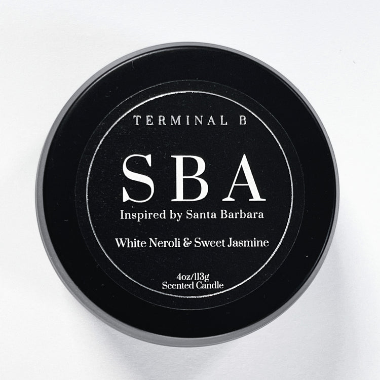 SBA 4oz Travel Tin candle by Terminal B. White Neroli & Sweet Jasmine fragranced and displayed against a white background. Inspired by Santa Barbara, carefully designed for an elegant, long-lasting scent.