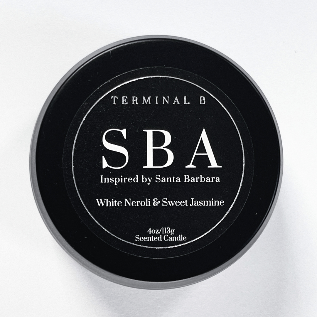 SBA 4oz Travel Tin candle by Terminal B. White Neroli & Sweet Jasmine fragranced and displayed against a white background. Inspired by Santa Barbara, carefully designed for an elegant, long-lasting scent.