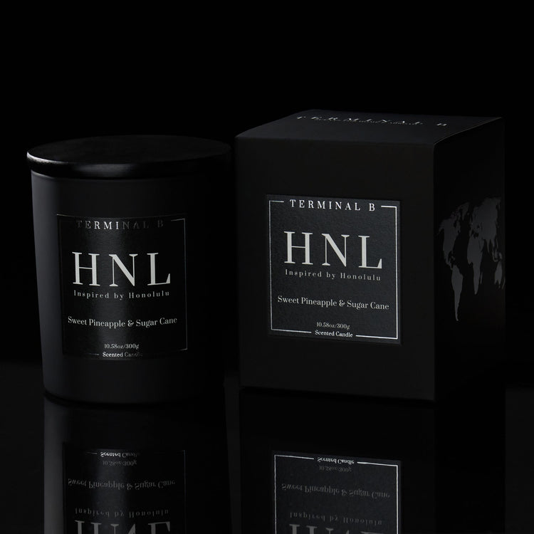 HNL luxury candle by Terminal B in Sweet Pineapple & Sugar Cane fragrance, displayed against a black background. Inspired by Honolulu, carefully designed for an elegant, long-lasting scent.